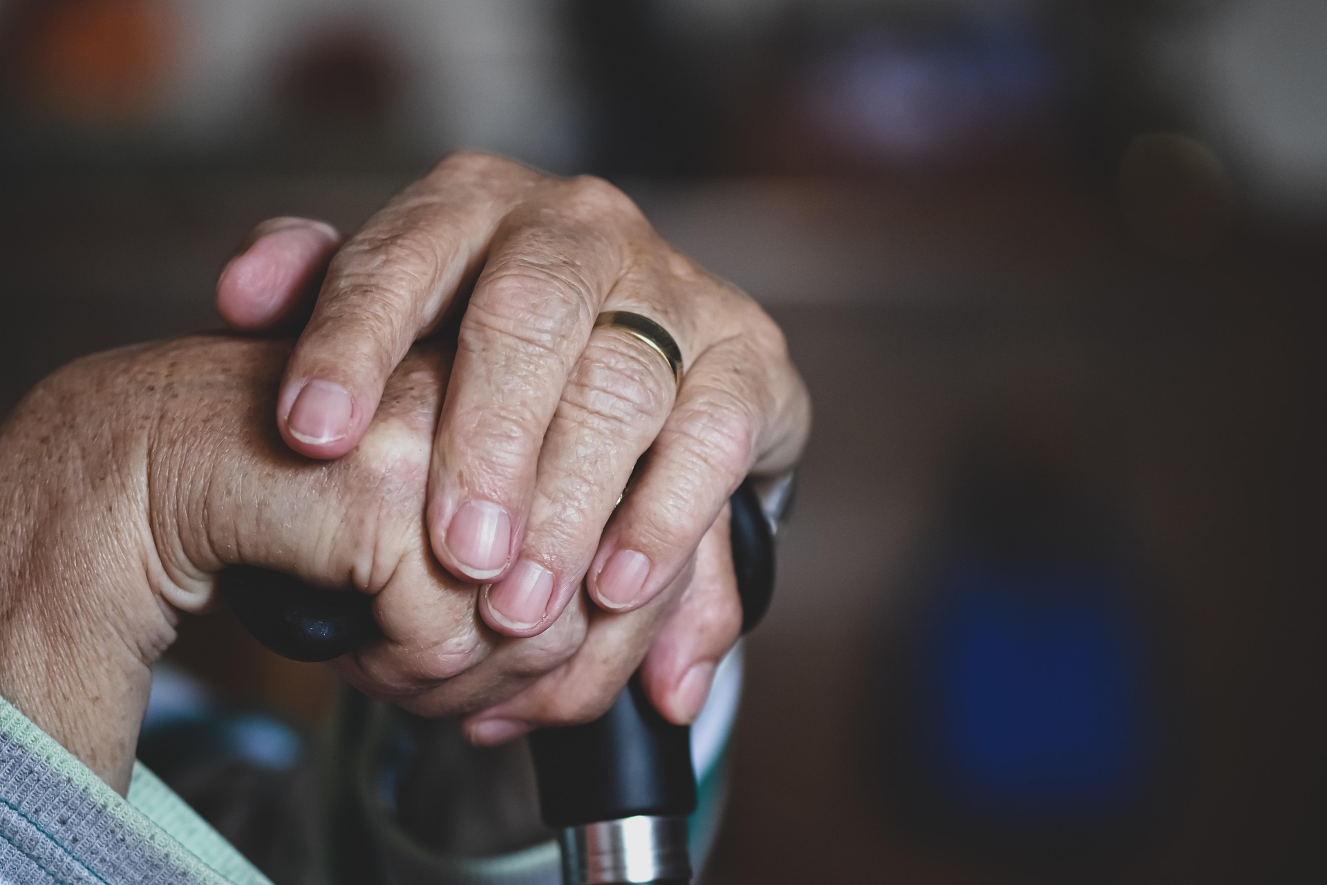 Client hands resting on cane